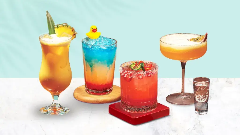 Four cocktails lined up on a pale blue background
